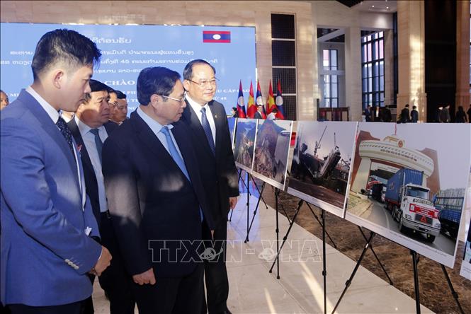 Thủ tướng Phạm Minh Chính và Thủ tướng Lào Sonexay Siphandone tham quan Trưng bày ảnh. Ảnh: TTXVN.