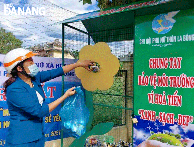 Hội viên Hội Liên hiệp Phụ nữ xã Hòa Tiến thực hiện phân loại rác tại mô hình “Mái nhà xanh”. Ảnh: T.AN	