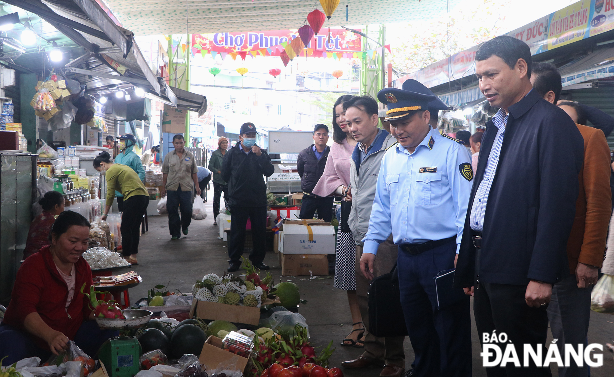 Phó Chủ tịch Thường trực UBND thành phố Hồ Kỳ Minh (đầu tiên, bên phải) hỏi thăm tình hình kinh doanh của tiểu thương chợ Cồn trong buổi kiểm tra thị trường vào sáng 20-1. Ảnh: VĂN HOÀNG