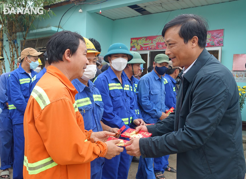 Giám đốc Sở Tài nguyên và Môi trường Phạm Nam Sơn (phải) lì xì và động viên các công nhân lái xe vận chuyển rác về bãi rác Khánh Sơn và công nhân vận hành bãi rác.