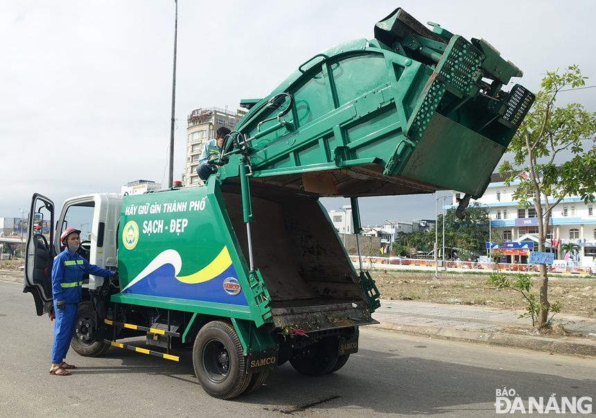Một xe ép rác cỡ nhỏ được kiểm tra trước khi bắt đầu một chu trình thu gom rác.