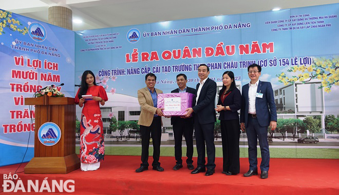 Chủ tịch UBND thành phố Lê Trung Chinh (thứ 3 từ phải sang) tặng quà cho đơn vị được giao làm chủ đầu tư, đơn vị thi công công trình Nâng cấp, cải tạo Trường THPT Phan Châu Trinh (cơ sở 154 Lê Lợi). Ảnh: HOÀNG HIỆP