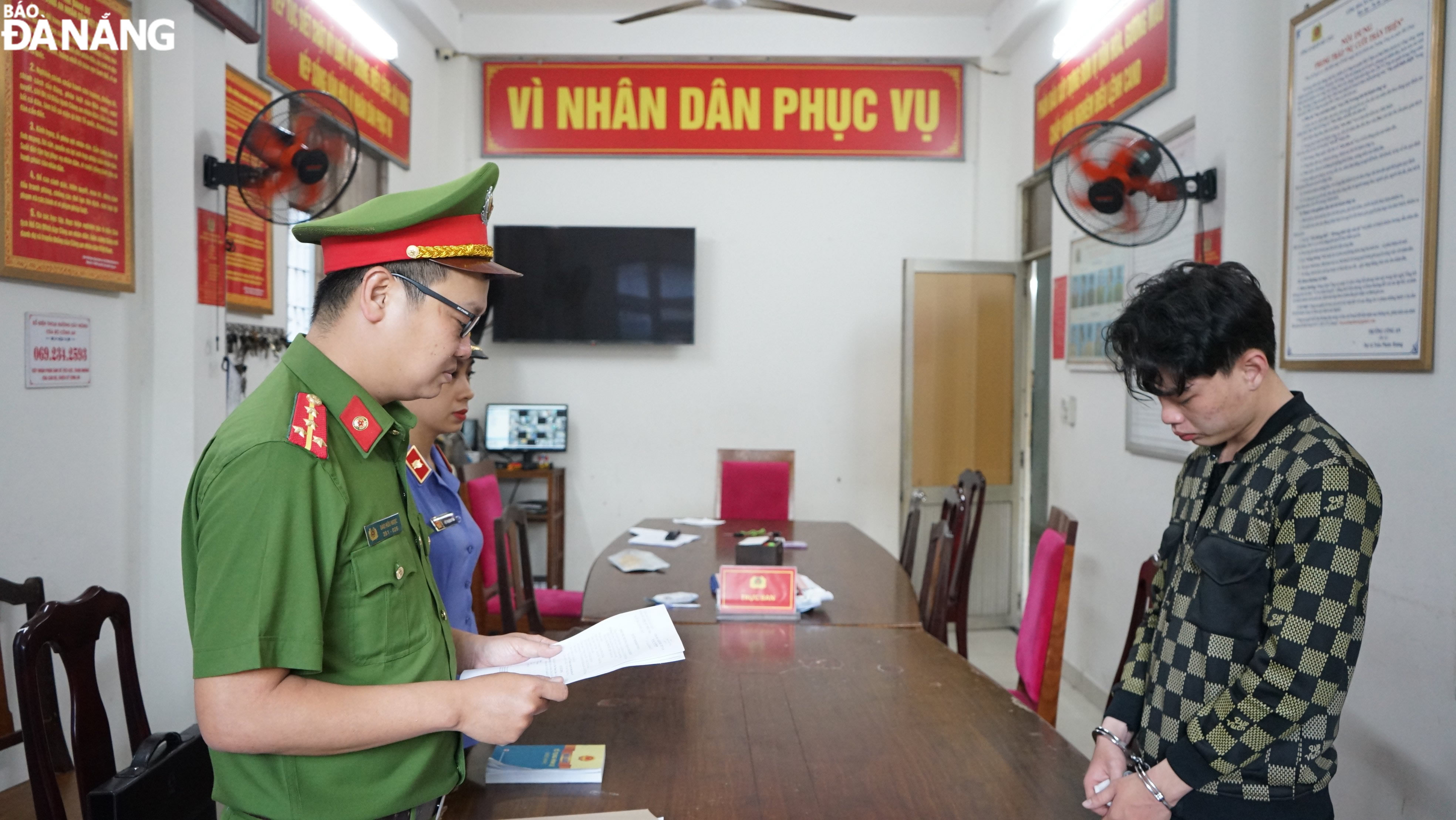 Cơ quan Cảnh sát điều tra, Công an quận Hải Châu thực hiện lệnh bắt tạm giam đối tượng Mai Phước Liêm (phải). Ảnh: L.H