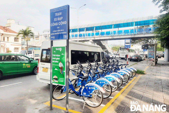 Một điểm thử nghiệm mô hình xe đạp công cộng ở Đà Nẵng và ứng dụng dịch vụ thuê xe TNGo trên điện thoại di động (ảnh nhỏ).  Ảnh: THÀNH LÂN