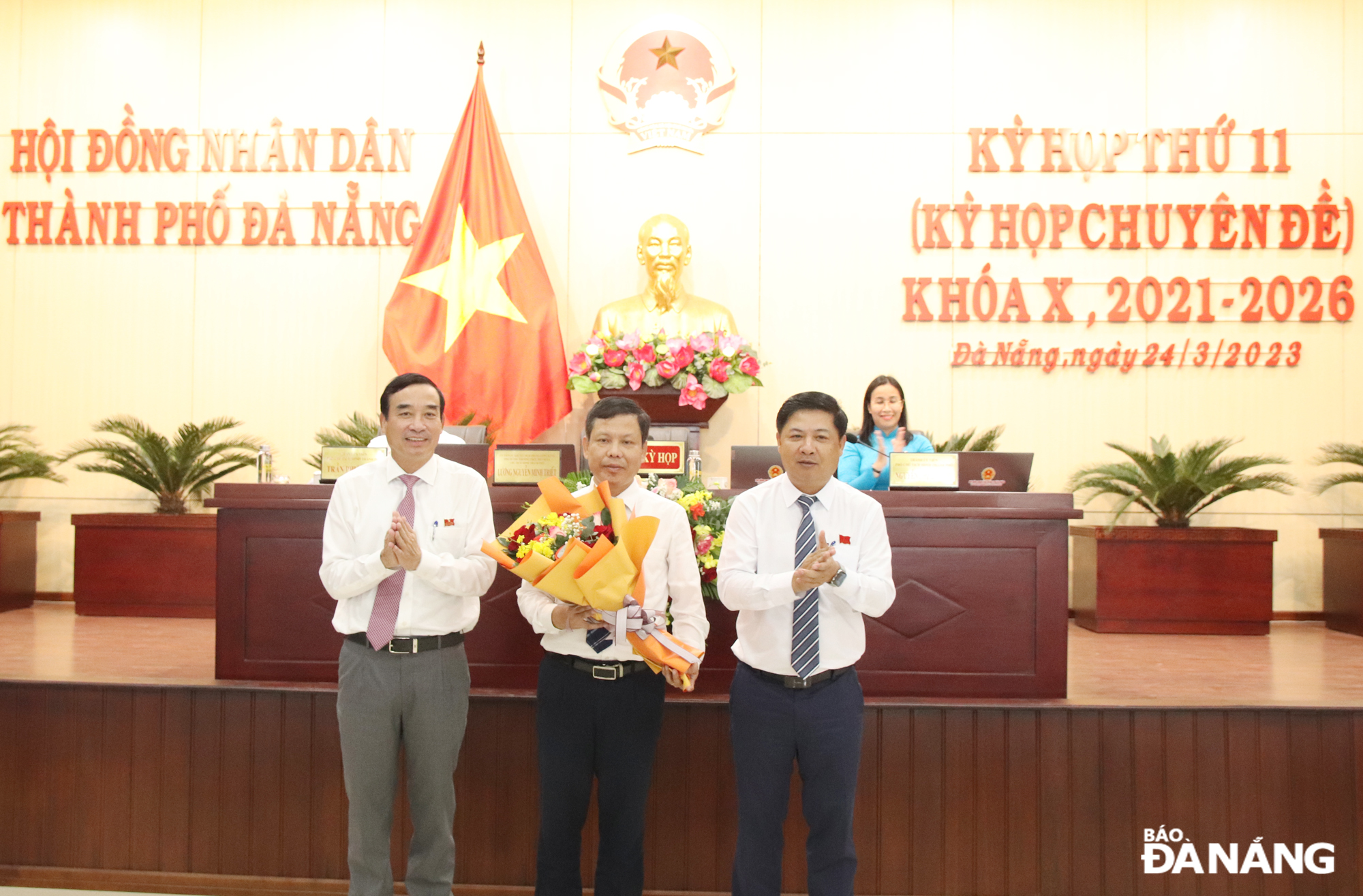 Chủ tịch HĐND thành phố Lương Nguyễn Minh Triết (bên phải) cùng Chủ tịch UBND thành phố (bên trái) tặng hoa chúc mừng ông Bùi Hồng Trung. Ảnh: TRỌNG HUY
