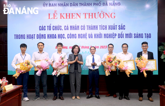 Phó Chủ tịch UBND thành phố Ngô Thị Kim Yến (thứ 4, bên trái sang) trao bằng khen của UBND thành phố cho các tác giả, nhóm tác giả có thành tích xuất sắc trong hoạt động khoa học và công nghệ trong chiều 17-5. Ảnh: VĂN HOÀNG	