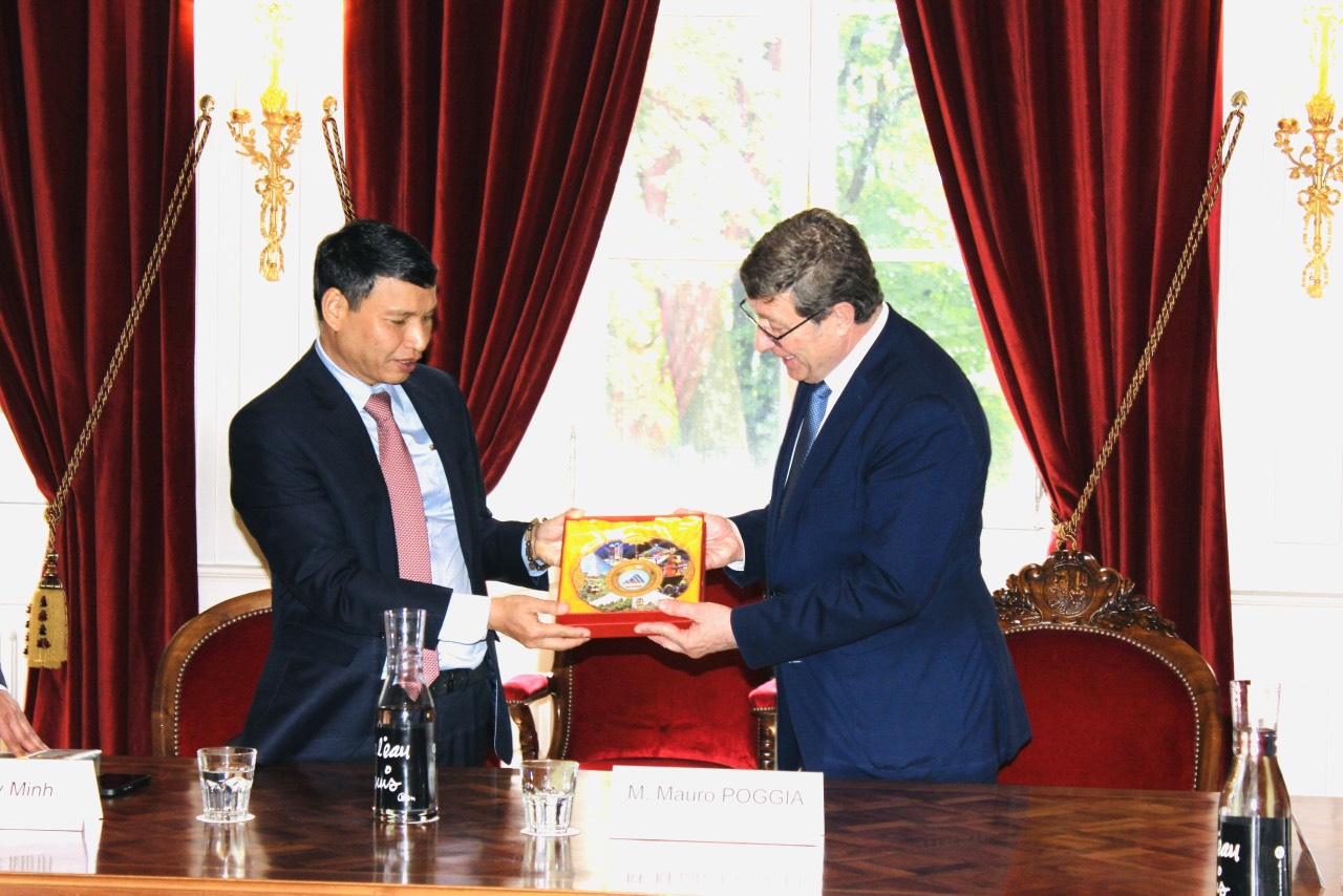 Phó Chủ tịch Thường trực UBND thành phố Hồ Kỳ Minh (bên trái) trao quà lưu niệm cho lãnh đạo chính quyền bang Geneva.