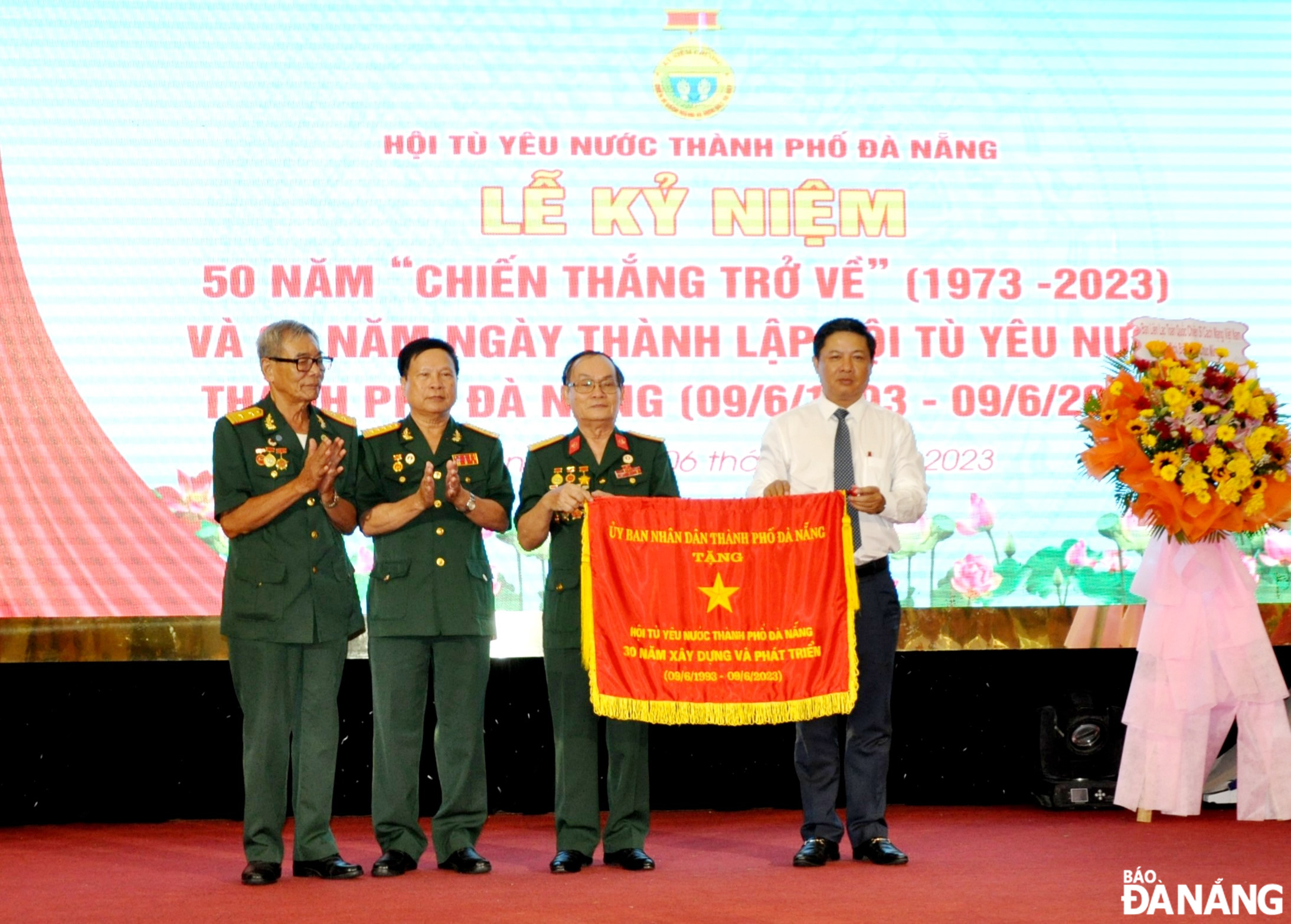 Phó Bí thư Thường trực Thành ủy Lương Nguyễn Minh Triết (bên phải) tặng cờ của UBND thành phố cho Hội Tù yêu nước thành phố. Ảnh: LÊ HÙNG