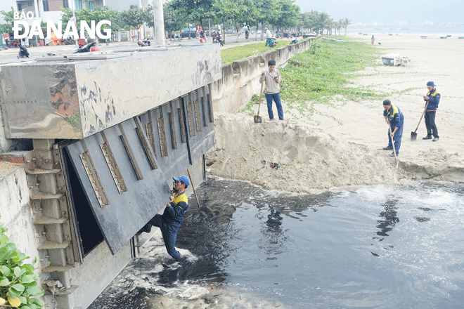 Công nhân Công ty Thoát nước và xử lý nước thải Đà Nẵng khắc phục sự cố nước mưa lẫn nước thải tràn ra biển sau một trận mưa to trong tháng 5-2023 ở phía bắc bãi tắm Mân Thái. Ảnh: H.H