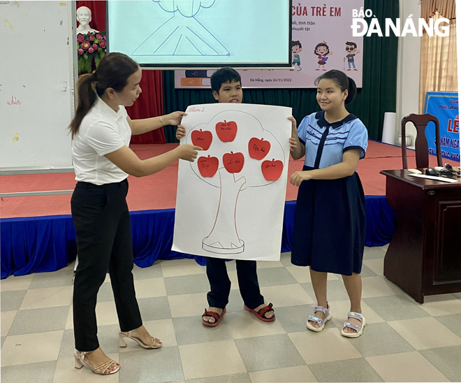 Cô giáo Hồ Thị Mỹ Dung (bìa trái) thực hiện chương trình chăm sóc mắt học đường cho trẻ khiếm thính do Sở Giáo dục và Đào tạo tổ chức.