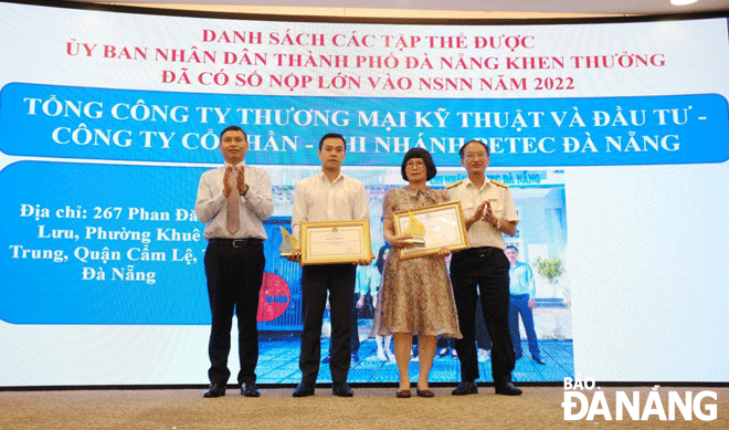 Phó Chủ tịch Thường trực UBND thành phố Hồ Kỳ Minh (bên trái) trao Bằng khen của UBND thành phố cho doanh nghiệp.   Ảnh: M.Q