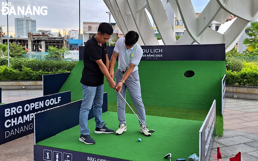 Du khách thích thú trải nghiệm đánh golf tại tầng 2 Công viên vườn tượng APEC. Ảnh: THU HÀ