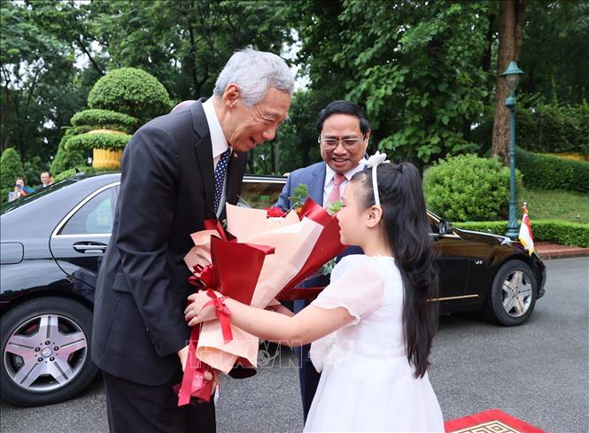 Thiếu nhi Thủ đô tặng hoa chào mừng Thủ tướng Singapore Lý Hiển Long. Ảnh: Dương Giang/TTXVN