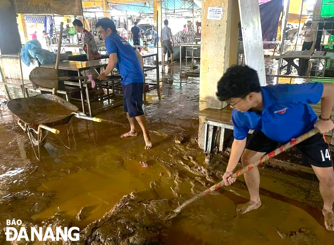 Đoàn viên, thanh niên phường Hòa Khánh Bắc (quận Liên Chiểu) ra quân dọn bùn đất tại chợ Thanh Vinh. Ảnh: H.T