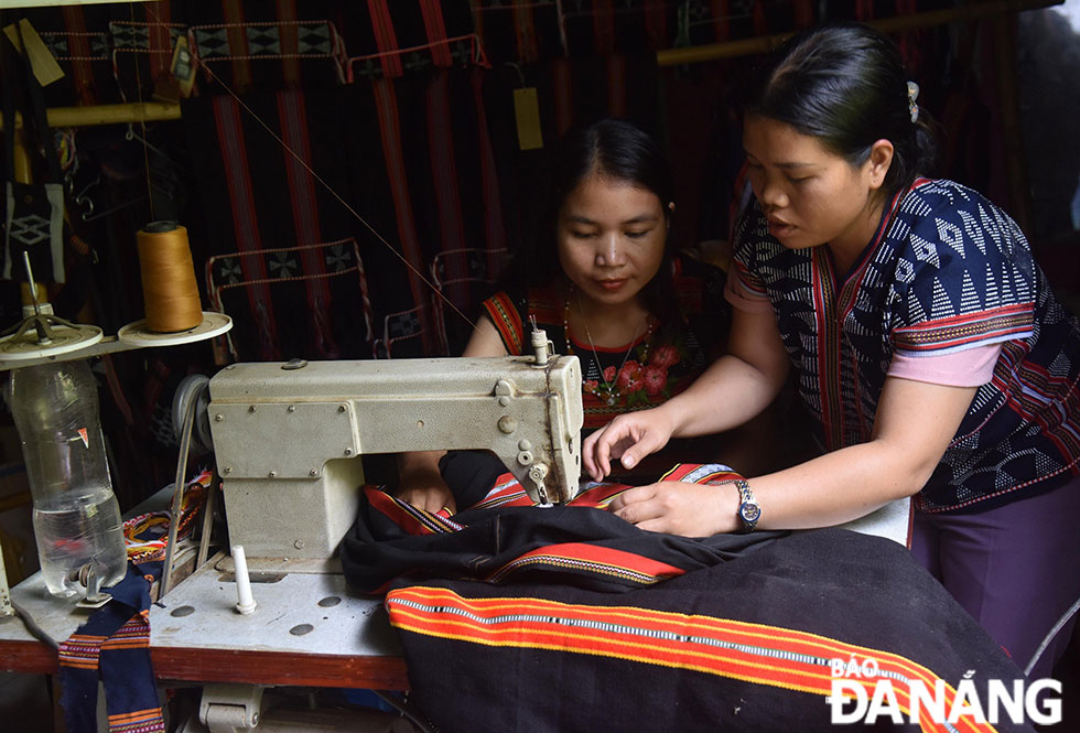 Thợ khâu đang hướng dẫn học viên những đường kim mũi chỉ, cắt may những bộ váy, áo truyền thống.