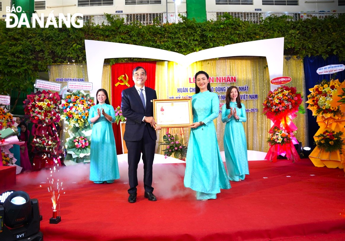 Thừa ủy quyền của Chủ tịch Nước, Chủ tịch UBND thành phố Lê Trung Chinh (thứ 2, bên trái sang) trao Huân chương Lao động Hạng Nhất cho Trường Mầm non 19-5. Ảnh: NGỌC QUỐC
