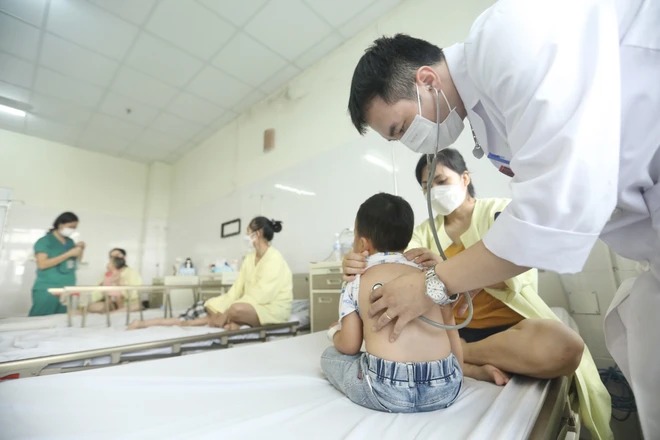 Bác sỹ khám, theo dõi sức khỏe cho trẻ mắc cúm A. (Ảnh: Minh Quyết/TTXVN))
