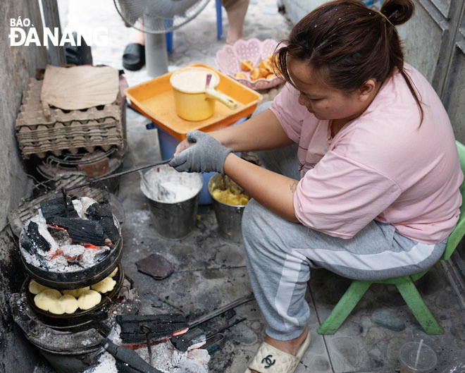 Chị Nguyễn Thị Thủy Tiên đang tỉ mỉ canh than trên lẫn than dưới để bánh chín đều, đẹp mắt. Ảnh: K.M