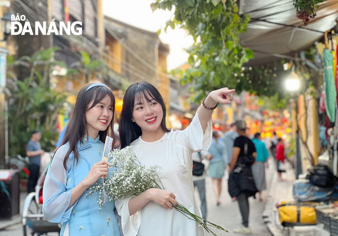 Chị Thái Thị Bảo Quyên (bên phải) và bạn thân chụp ảnh cùng tà áo dài đón Tết tại phố cổ Hội An . Ảnh: H.T.V