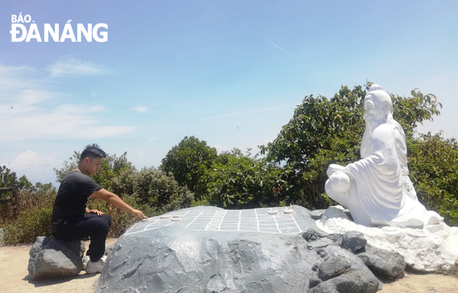 A tourist admires the statue of De Thich deity on the Ban Co Peak