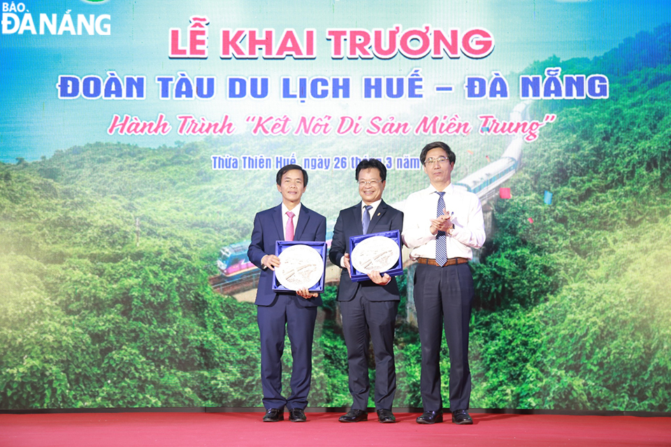Phó Chủ tịch UBND Đà Nẵng Trần Chí Cường (ngoài cùng bên phải) tặng quà lưu niệm cho Chủ tịch UBND tỉnh Thừa Thiên Huế và Chủ tịch Hội đồng thành viên Tổng Công ty Đường sắt Việt Nam. Ảnh: CHIẾN THẮNG