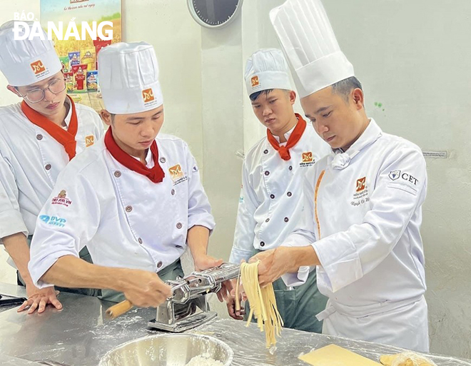 Anh Nguyễn Văn Hậu đang hướng dẫn học viên thực hành chế biến món ăn.