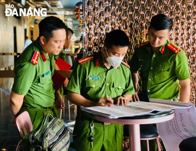 Thượng úy Đặng Ngọc Lâm (bên phải) cùng đồng đội thực hiện kiểm tra an toàn phòng cháy chữa cháy tại các cơ sở kinh doanh có điều kiện.