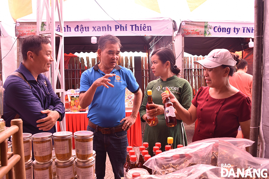  Da Nang people and tourists visit local traditional products at booths. Photo: THU HA