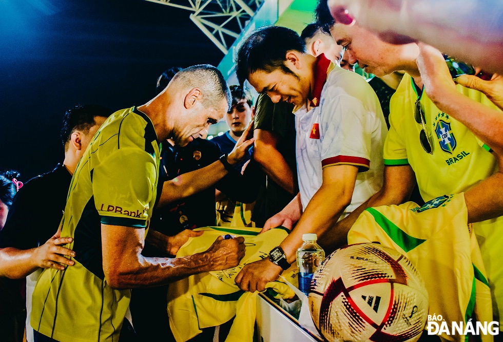 Brazilian legend Rivaldo who won the 1999 Ballon d'Or award by FIFA signs autographs to Vietnamese fans