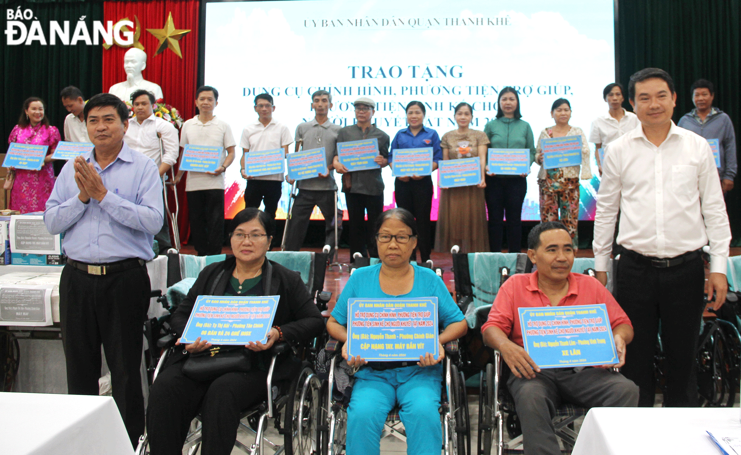 Phó Chủ tịch UBND quận Thanh Khê Nguyễn Hữu Công (hàng đầu, bên phải) trao sinh kế và xe lăn cho người khuyết tật trên địa bàn quận. Ảnh: L.P